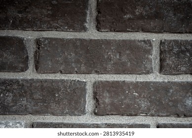 Close-up of Used Brick Smoke Stack manufactured brick veneer featuring deep charcoal and dark brown tones with an authentic reclaimed brick appearance. The detailed masonry texture makes an ideal architectural background for exterior facades, interior accent walls, fireplaces, residential and commercial construction, industrial-style interiors, home renovation, restoration projects, and decorative brick cladding. Toronto, Canada - June 01, 2026.