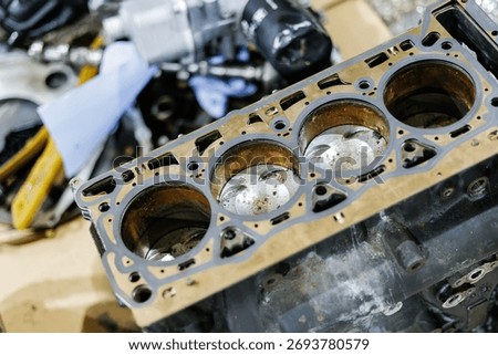 Close-up of used car engine block with visible cylinders and pistons.