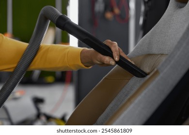 Closeup of vacuuming car interior from dust using professional equipment - Powered by Shutterstock