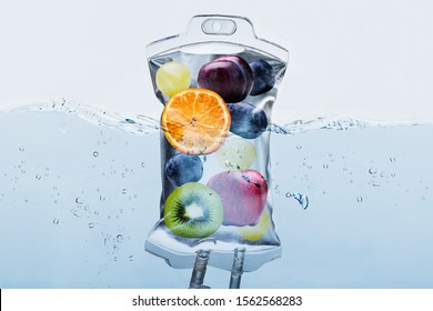 Close-up Of Various Fruit Slices In Saline Bag Dip In Water Against White Background