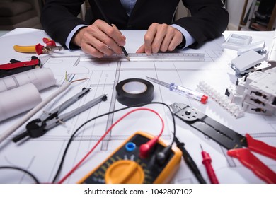 Close-up Of Various Worktools In Front Of Architecture's Hand Drawing Blueprint