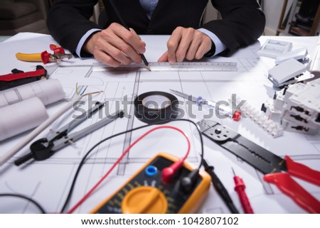 Close-up Of Various Worktools In Front Of Architecture's Hand Drawing Blueprint