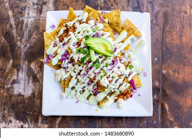 Closeup Vegan Chilaquiles Nachos On White Plate, Isolated Wood Background