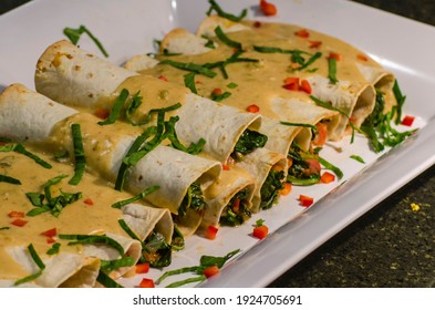 A close-up of vegan enchiladas with spinach and bell pepper - Shutterstock ID 1924705691