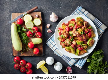 close-up of vegetable marrow Ratatouille with chicken meat served on a white plate on a concrete table with ingredients, horizontal view from above - Powered by Shutterstock