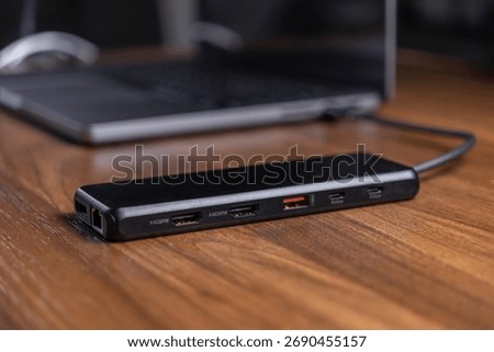 Close-up of a versatile black USB-C docking station with power delivery and multiple display outputs, expanding laptop connectivity for enhanced digital workspace productivity