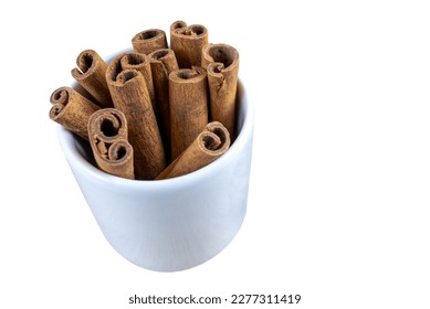 close-up of vertical cinnamon stick inside ceramic glass on white background - Shutterstock ID 2277311419