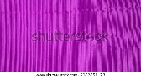 close-up vertical stripes of purple pleated fabric banner, vibrant colored fabric with wavy rough surface for abstract texture background