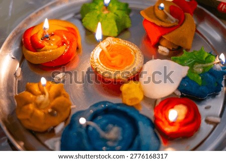 Closeup of vibrant handmade aata flour diyas with glowing flames, arranged on a plate, capturing festive Diwali spirit and traditional Indian celebration.