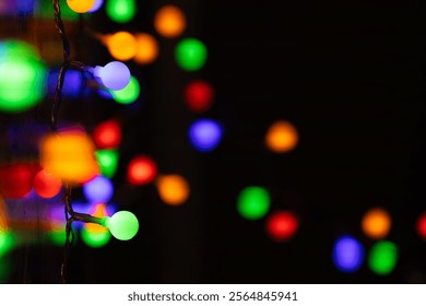 Close-up of vibrant, multicolored string lights glowing in the dark, creating a festive and cozy atmosphere. Defocused lights add depth and bokeh effect