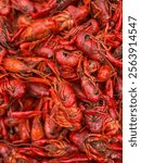 A close-up of vibrant red crawfish, their glossy shells glistening with steam, arranged in a rustic pile, showcasing their detailed claws and segmented tails