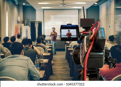 Closeup Video Recording The Asian Speaker With Casual Suit On The Stage Over The Presentation Screen In The Meeting Room Of Business Or Education Seminar, Event And Seminar Concept