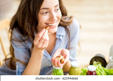 Closeup view from above of a woman eating brasil nuts with healthy food on the background