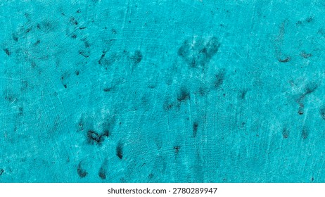 A close-up view of an abstract textured surface with swirling patterns in shades of blue and teal, creating a visually dynamic and organic feel.