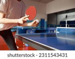 Closeup view of adult woman playing table tennis in gym