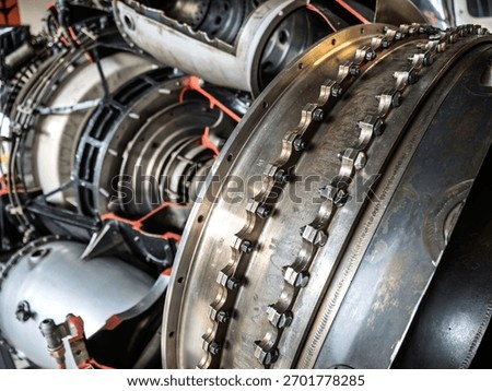 Close-up view of an aircraft engine section showing metal bolts, rings, and turbine components, highlighting the engineering precision, mechanical complexity, and industrial craftsmanship.