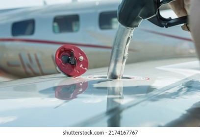 A close-up view of the aircraft's fuel tank, fuel is being filled into the tank. Fuel nozzle filling up aircraft, refueling jet fuel in an aircraft wing.  - Shutterstock ID 2174167767