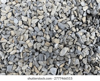 A close-up view of assorted small gray rocks and gravel forming a textured surface.