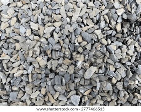 A close-up view of assorted small gray rocks and gravel forming a textured surface.