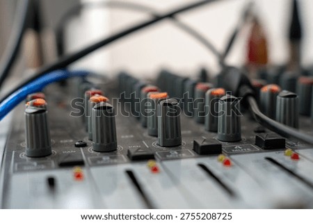 Close-Up View of an Audio Mixing Console with Focus on Knobs and Cables for Sound Engineering Applications