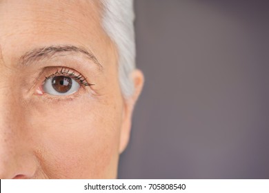 Closeup view of beautiful elderly woman on gray background - Shutterstock ID 705808540