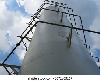 Close-up View From Below To The Top Of Buffer Tank In LNG Facility On Cloudy Day