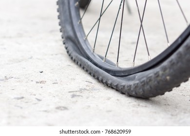 Closeup View Of Bicycle Flat Tire On Pavement.