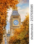 Close-up view of the Big Ben tower in London during golden autumn time with lush foliage