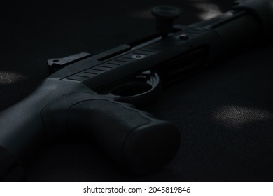 Closeup view of black shotgun which is on the black leather background, concept for shooting sport, security and bodyguard training, soft and selective focus.