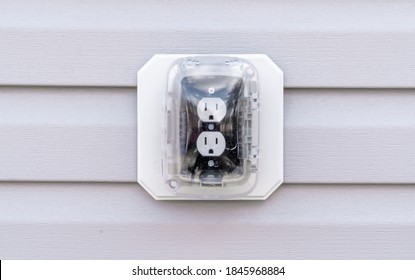 Closeup View Of Black Socket White Double Outlet Plug With Plastic Cover On A House Wall