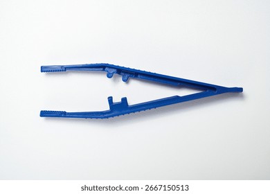 Closeup view of blue plastic forceps or a tweezer tool isolated over a white background