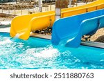 Close-up view of blue and yellow waterslide at aquapark outdoor pool