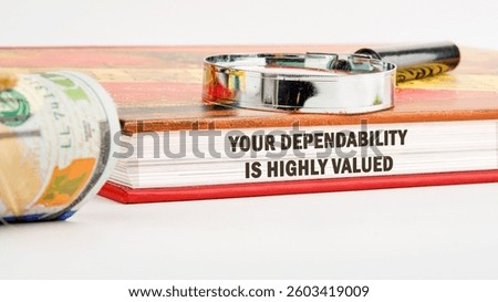 A close-up view of a book showcasing the phrase Your dependability is highly valued alongside a banknote and a magnifying glass, emphasizing principles of trust in business.