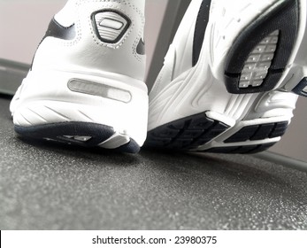 Closeup View Of Brand New Sport Shoes Running Walking On A Treadmill (low Angle Perspective, With Copy Space)