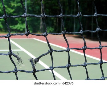 Close-up View Of A Broken Tennis Net - Lines Of The Court Shown In Background