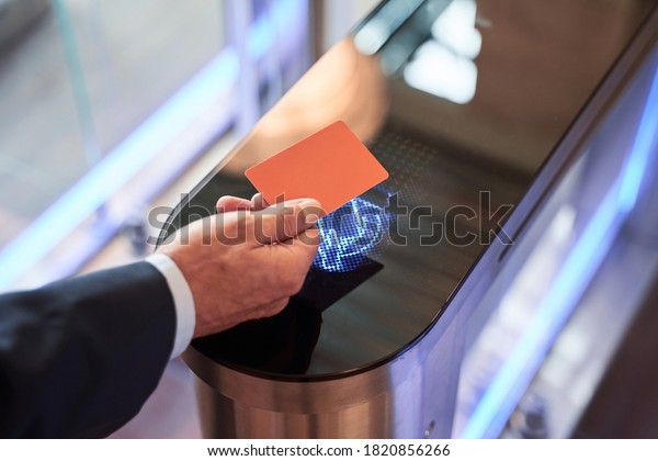 Close-up view of businessman scanning his card at\
turnstile gate