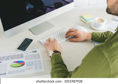 Close-up view of businessman typing on computer keyboard at home office - Shutterstock ID 1051987928