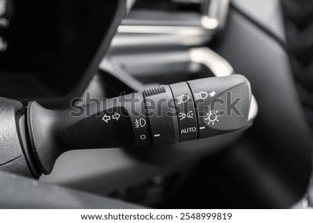 Close-up view of the car headlight switch controls.