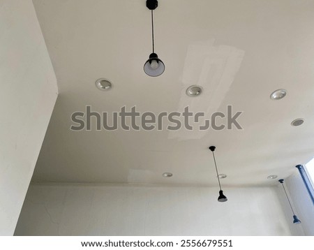 A close-up view of a ceiling light fixture mounted on a roof, showcasing its sleek and minimalistic design.