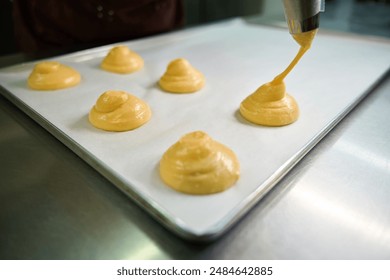 Close-up view circles from pastry dough piping out from pastry bag - Powered by Shutterstock