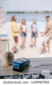 Close-up View Of Cocktail, Credit Cards And Payment Terminal On Wooden Bar Counter At Beach Bar