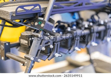 Close-up view of a combat quadcopter assembly, made of metal components with screws and bolts, resembling an arm or bracket Dark metallic tones suggest steel or alloy materials No contextual backgr