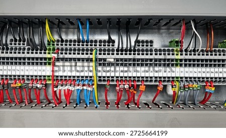 A close-up view of a complex electrical control panel with numerous wires and terminal blocks, organized and labeled for industrial use.