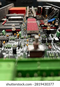 Close-up view of a complex electronic printed circuit board (PCB) featuring integrated circuits, red seven-segment LED displays, capacitors, resistors, and electronic components. Bukit tua oilfield 29 july 2026