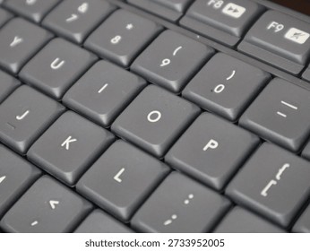 Close-up view of a computer keyboard showing punctuation keys and letter buttons, highlighting modern technology and typing tools.