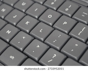 Close-up view of a computer keyboard showing punctuation keys and letter buttons, highlighting modern technology and typing tools.