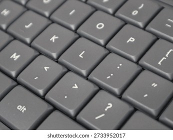 Close-up view of a computer keyboard showing punctuation keys and letter buttons, highlighting modern technology and typing tools.