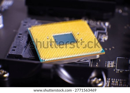Close-up view of computer processor with gold pins positioned on motherboard. Focus on circuitry and silicon chip components with blurred background. Detailed texture of electronic hardware showcasing