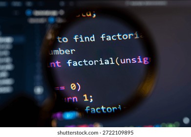 Close-up view of a computer screen displaying colorful programming code under a magnifying glass, highlighting a function named "factorial" in a software development environment. - Powered by Shutterstock - Get 15% off with code: PIKWIZARD15
