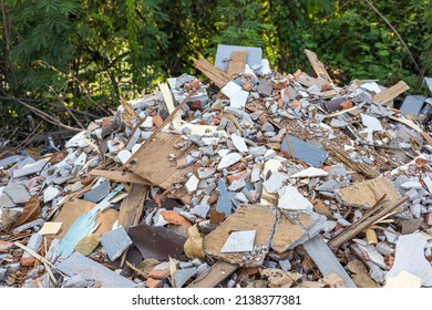 Close-up view of concrete rubble, bricks and small pieces of wood that have been demolished from old blooms and dumped near the bushes that are common in rural Thailand.